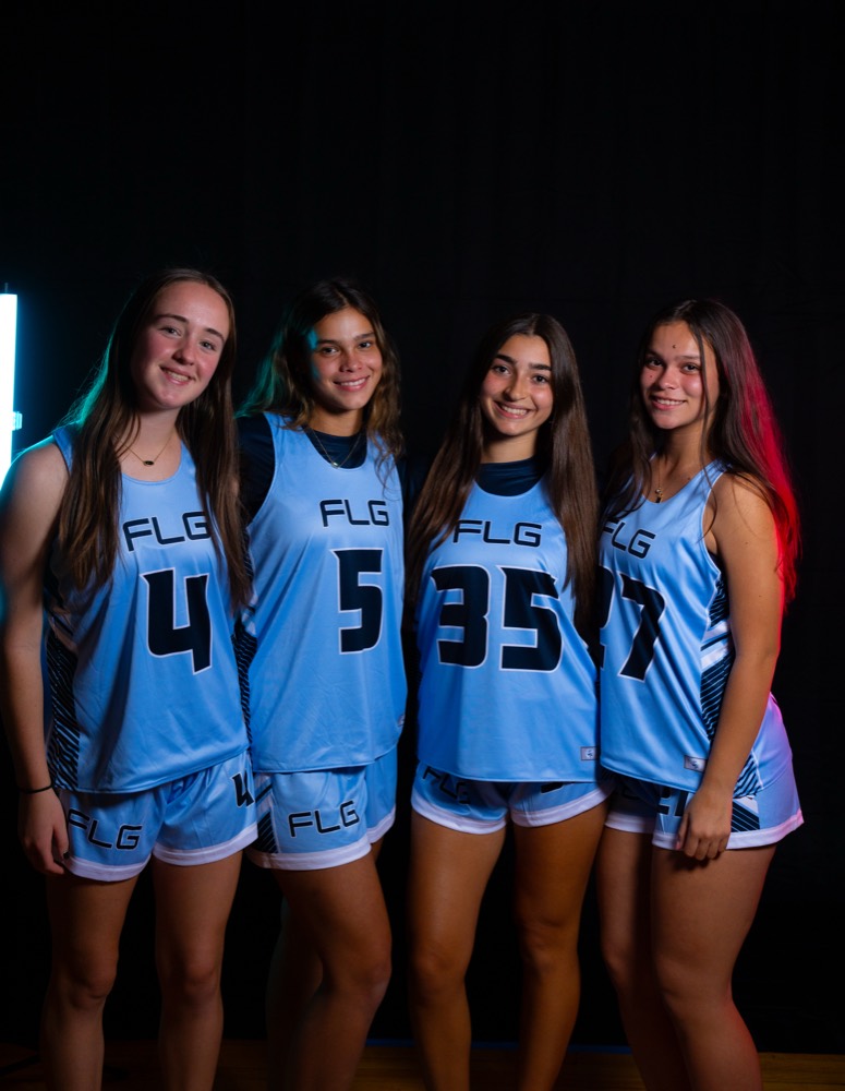 Four FLG players in Carolina blue uniforms standing shoulder to shoulder.